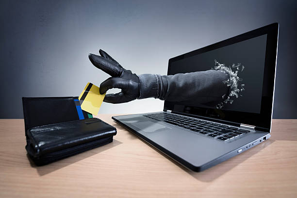 Internet crime and electronic banking security Stealing a credit card through a laptop concept for computer hacker, network security and electronic banking security thief stock pictures, royalty-free photos & images