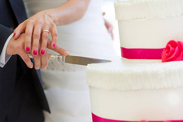 istock bride and groom cutting wedding cake 480139583