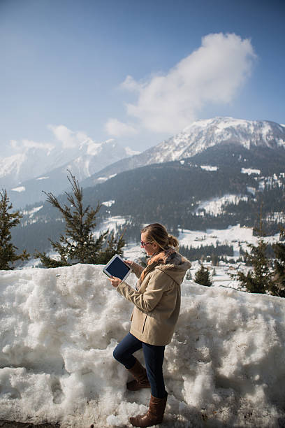 istock Woman with tablet on snowy mountains 480140717