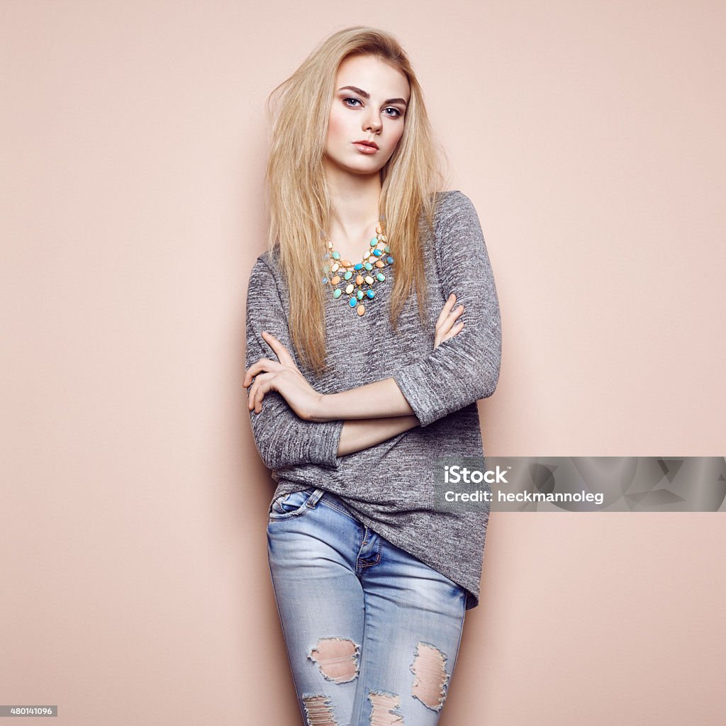 Fashion portrait of beautiful young woman with blond hair Fashion portrait of beautiful young woman with blond hair. Girl in blouse and jeans. Jewelry and hairstyle Forearm Stock Photo