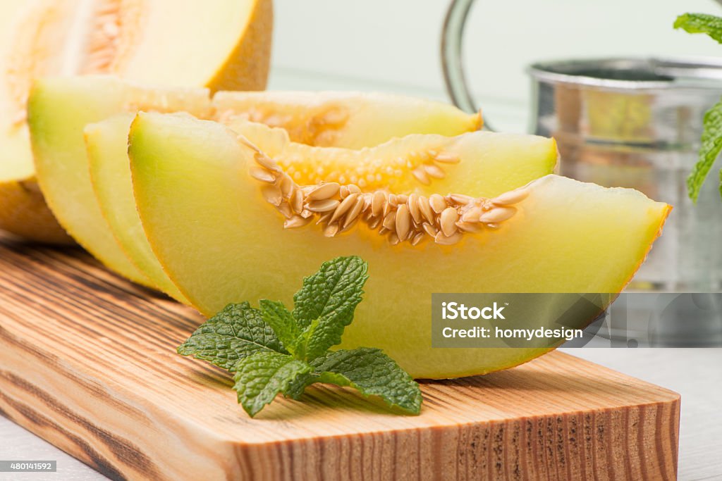 Honeydew melon Juicy honeydew melon on a wooden table background. Melon Stock Photo