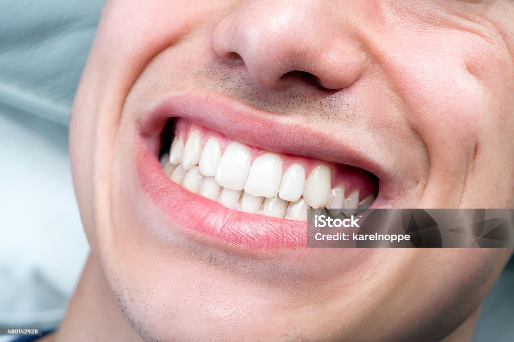 Extreme close up of human male mouth showing teeth. Macro close up of human male mouth showing perfect white teeth. 2015 Stock Photo