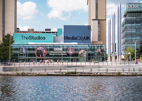 Manchester, UK - July 4, 2015: People outside the entrance to the BBC studios and offices at MediaCityUK in Salford Quays.