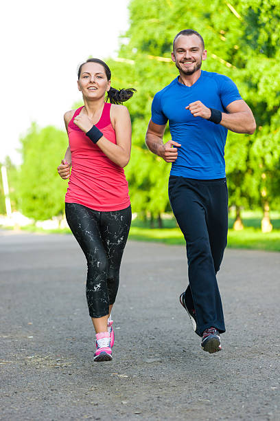istock Runners training outdoors working out. City running couple jogging outside 480143088