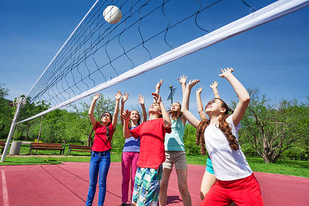 istock Group of teens with arms up play volleyball 480143220