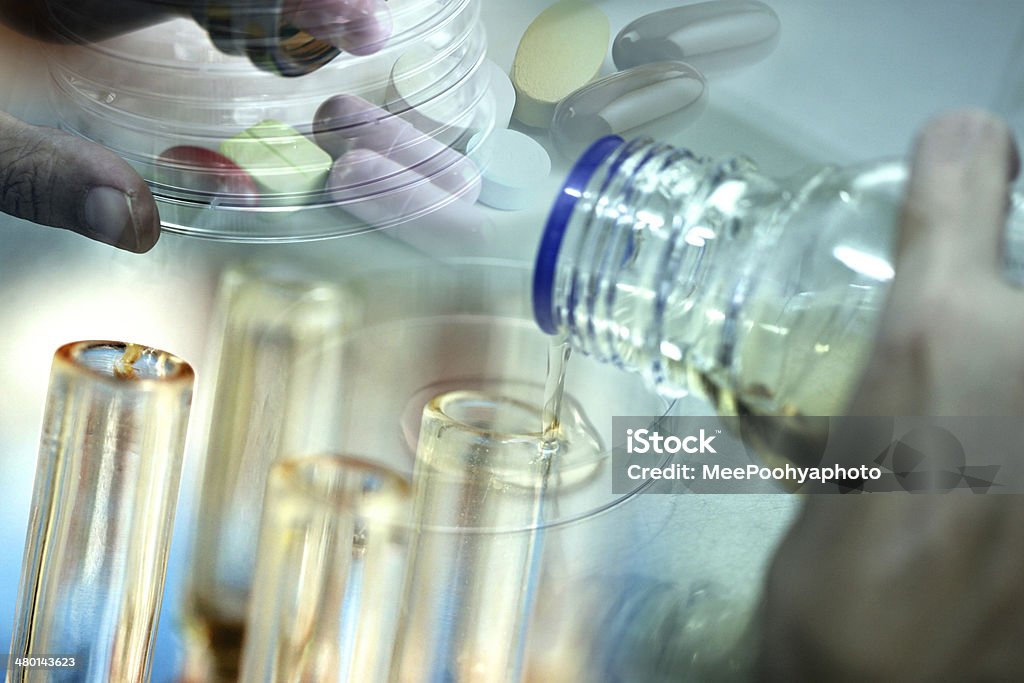 Adding agar fluid from bottle to test tubes. Adding agar fluid from bottle to test tubes in laboratory. Agar Jelly Stock Photo