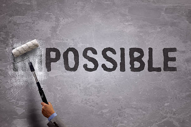 From impossible to the possible Changing the word impossible to possible by painting over and erasing part of the word with a paint roller on a concrete wall impossible possible stock pictures, royalty-free photos & images