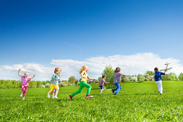 istock Boy with airplane toy and kids row running after 480144266