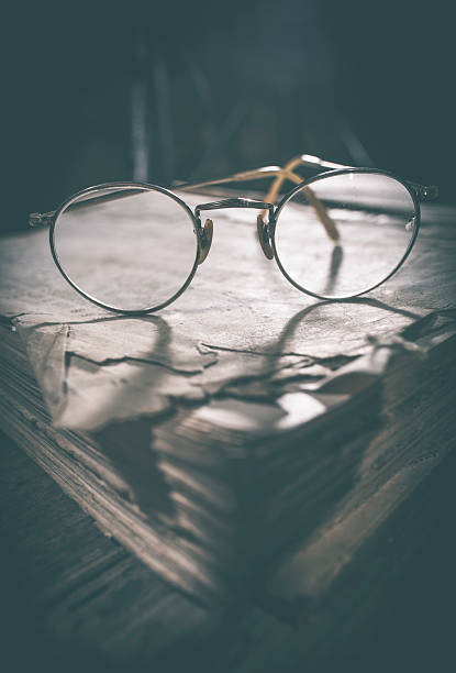 istock Old vintage round glasses and book 480151236