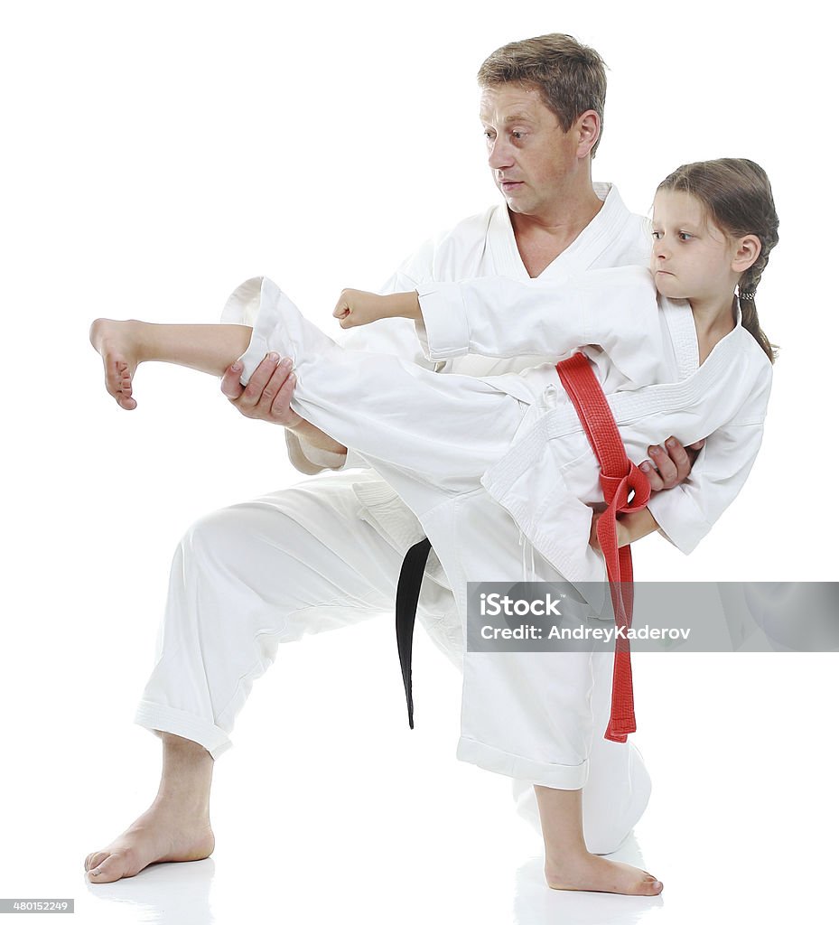 Girl learns to beat  kick leg on white background Belt Stock Photo