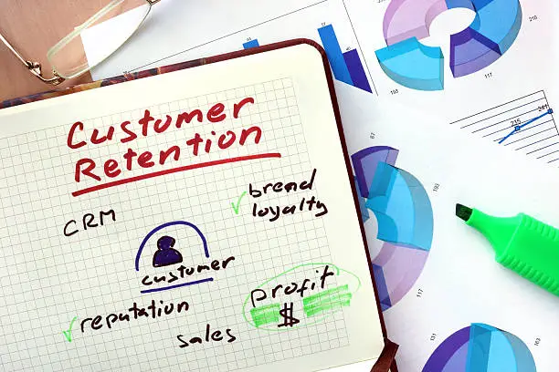 Photo of Notepad with words customer retention  concept and marker.