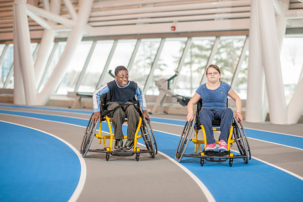 deux amis dans la salle de sport pour les personnes à mobilité réduite - disabled teenager adolescence physical impairment photos et images de collection