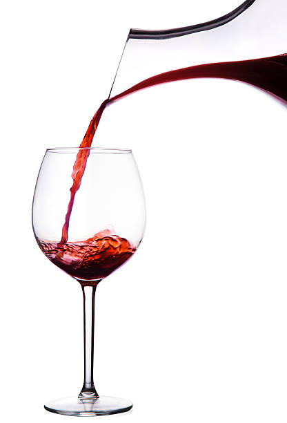 decanter con vino rosso versare nel bicchiere isolato su bianco - wine bottle bottle burgundy wine foto e immagini stock