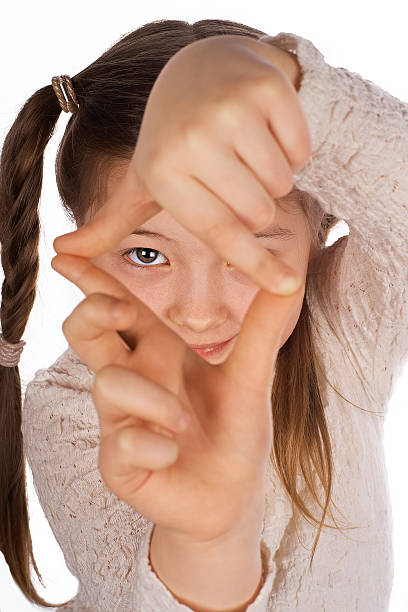 Funny girl making frame with hands Funny girl, making frame with hands, taking picture with imaginary camera, selective focus determination focus the bigger picture human hand stock pictures, royalty-free photos & images