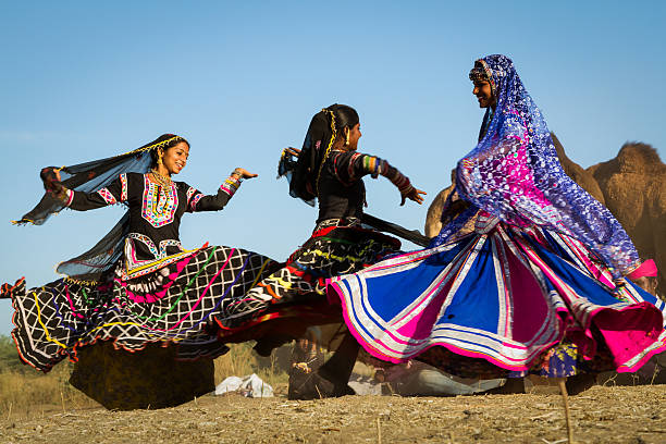 Girls doing folk dance at Pushkar Fair Pushkar, Rajasthan, India - November 25, 2012: Girls doing folk dance at Pushkar Fair. It’s the world's largest annual cattle fair in the desert town of Pushkar, in the Indian state of Rajasthan. Every year thousands of camel herders, who make a living rearing animals, travel for two to three weeks across many kilometers to set up camp in the desert dunes near Pushkar to sell their livestock. rajasthan stock pictures, royalty-free photos & images