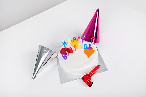 istock Birthday cake with party hats and noisemaker on table 480167707