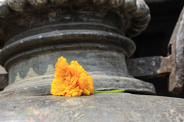 An offering of a yellow flower at a Buddhist temple