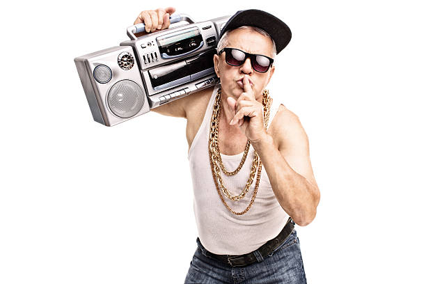 Mature rapper holding a finger on his lips Mature man in hip-hop clothes carrying a ghetto blaster over his shoulder and holding a finger on his lips isolated on white background gangster rap stock pictures, royalty-free photos & images