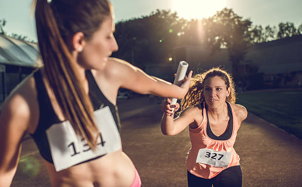 istock Female athletes exchanging baton on a relay race. 480170484