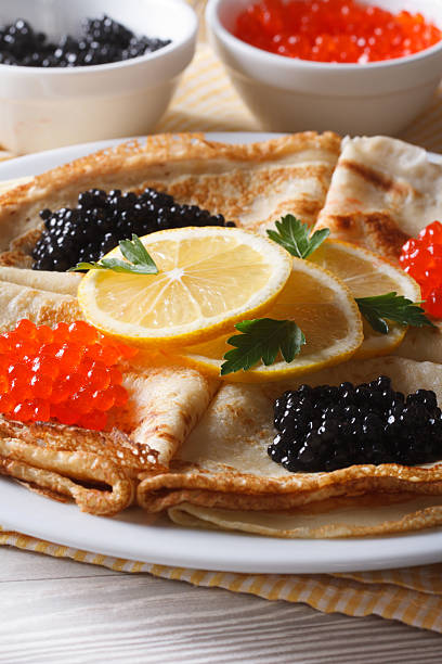 istock Thin pancakes with red and black caviar close-up, vertical 480170538
