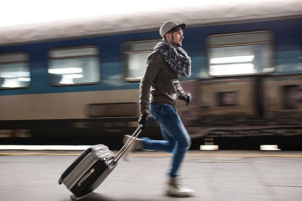 Young man in blurred motion trying to catch the train. Young man running at railroad station and trying to catch the train. Blurred motion. running to catch the train stock pictures, royalty-free photos & images