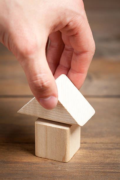 istock Wooden toy house with hand on old table 480173242