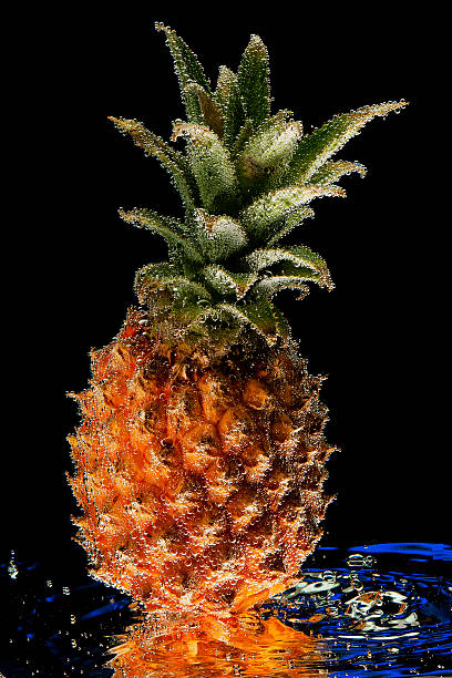 istock Fresh pineapple on water splashes with bubbles against a dark 480173936