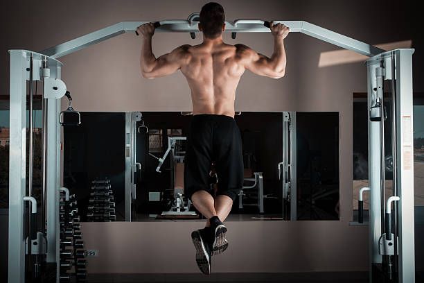 pull ups Strong man doing pull ups chin ups photos stock pictures, royalty-free photos & images