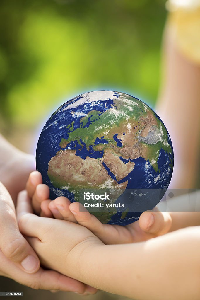 Children holding Earth in hands Children holding Earth in hands against green spring background. Elements of this image furnished by NASA Advertisement Stock Photo