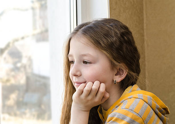 istock the girl at a window sits 480178331