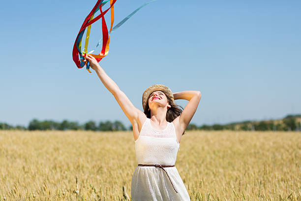 menina feliz segurando fitas coloridas - wind textile women retro revival - fotografias e filmes do acervo