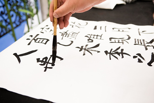 A person is learning Chinese calligraphy.