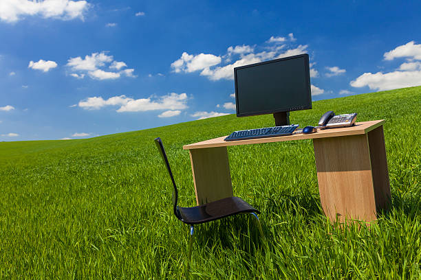 istock Desk and Computer In Green Field With Blue SKy 480178587