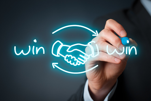 Win-win partnership strategy concept. Businessman draw win-win scheme with handshake partnership agreement.