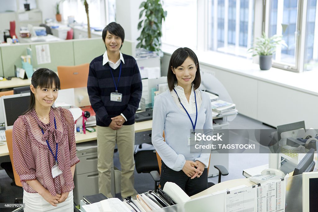 Man and woman standing by desk Japanese Ethnicity Stock Photo