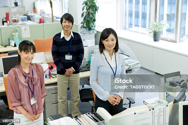 Man And Woman Standing By Desk Stock Photo - Download Image Now - Japanese Ethnicity, Office, Portrait