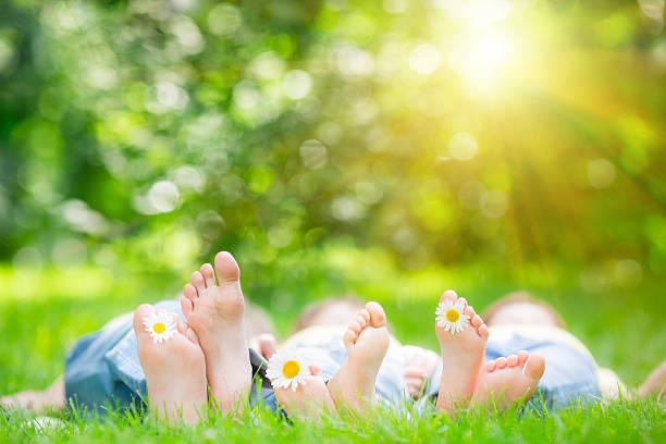 famiglia sdraiato su un erba - barefoot foto e immagini stock