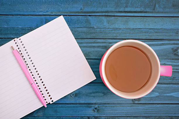 istock cup of tea and notebook on wood table 480179642