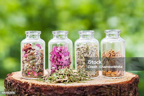 Bottles With Healing Herbs On Wooden Stump Stock Photo - Download Image Now - 2015, Alternative Medicine, Aromatherapy
