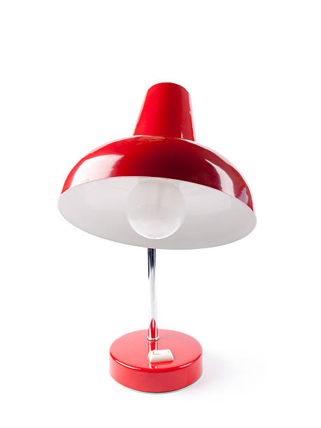 An old vintage red desk lamp with a light bulb stock photo