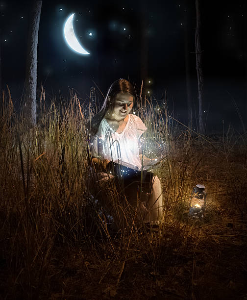istock woman sitting at night forest and reading fairy tale book 480188330