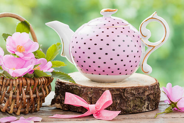 istock Tea kettle and basket with pink wild roses. 480188432