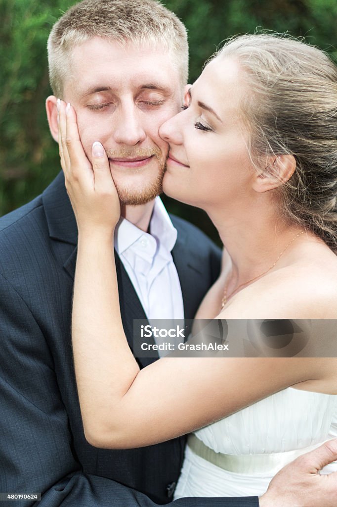 Bride and groom pressed cheeks Bride pressed his cheek to cheek the groom and gently strokes his the other cheek with closed eyes 2015 Stock Photo