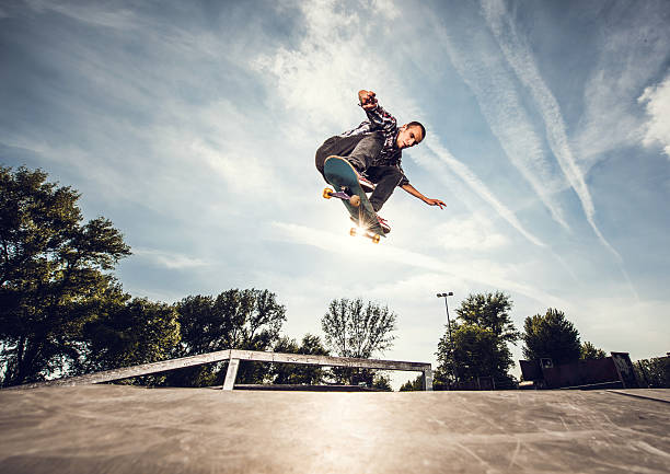 poniżej widok ulicy skateboarder w zrobić ollie pozycji. - ollie zdjęcia i obrazy z banku zdjęć