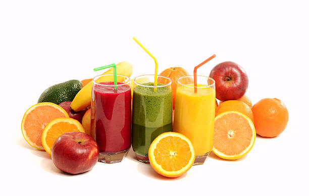 Pile of fruits and three glasses with fresh smoothie. stock photo