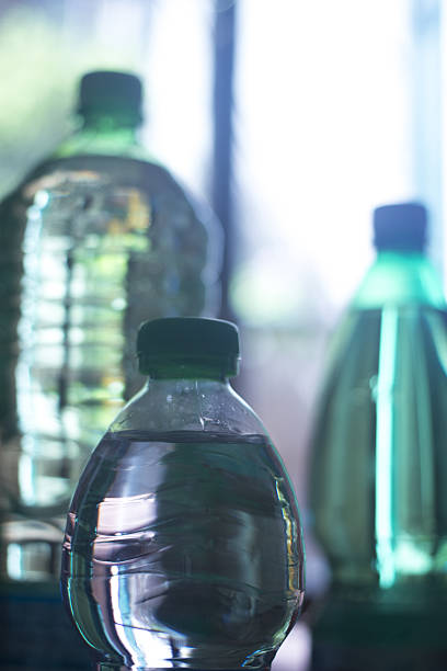 plástico botellas de agua en la ventana de luz - water bottle water bottle drink fotografías e imágenes de stock