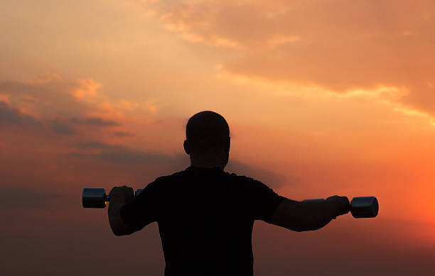 istock Silhouette weight lifting at sunrise 480207208