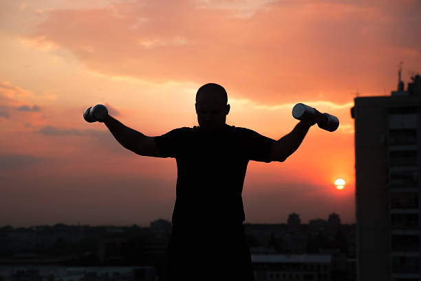 istock Silhouette weight lifting at sunrise 480208138