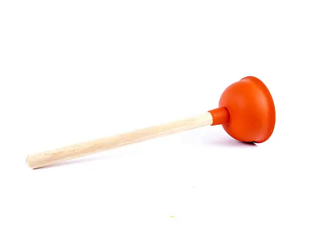 Red plunger used for unclogging toilets or sinks isolated over white