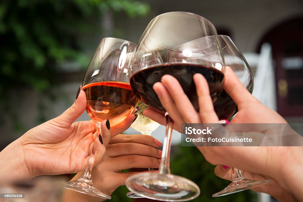 Toasting with wine. Group of unrecognizable people holding wine glasses and toasting. Celebratory Toast Stock Photo